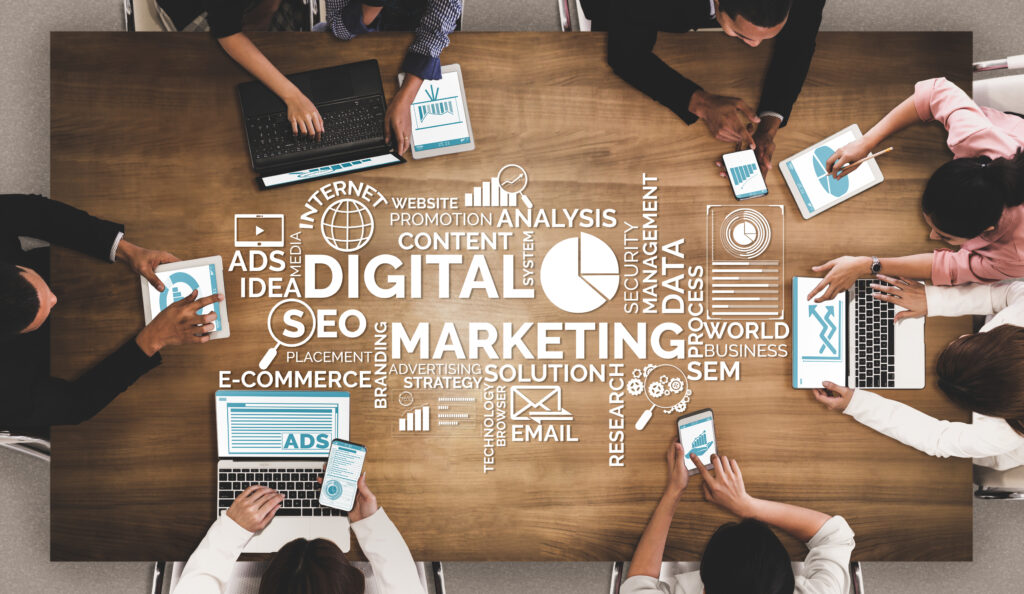 People gathered around a table with marketing-related words on